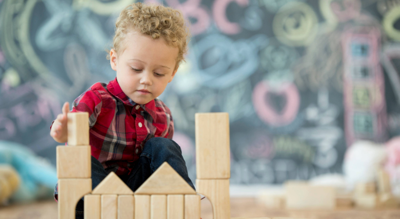 child playing with wooden blocks